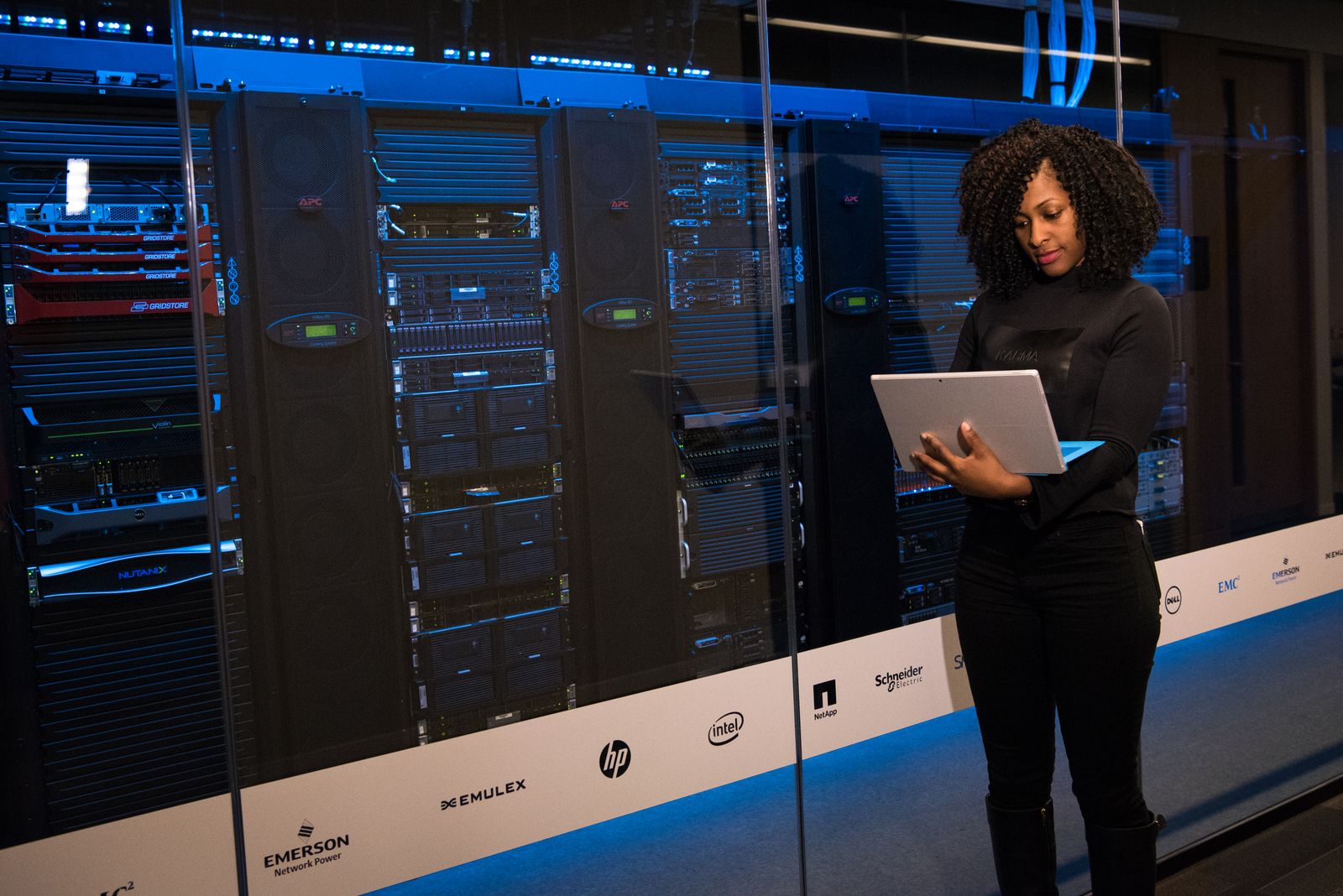 Μηχανικός με laptop δίπλα σε ικριώματα servers