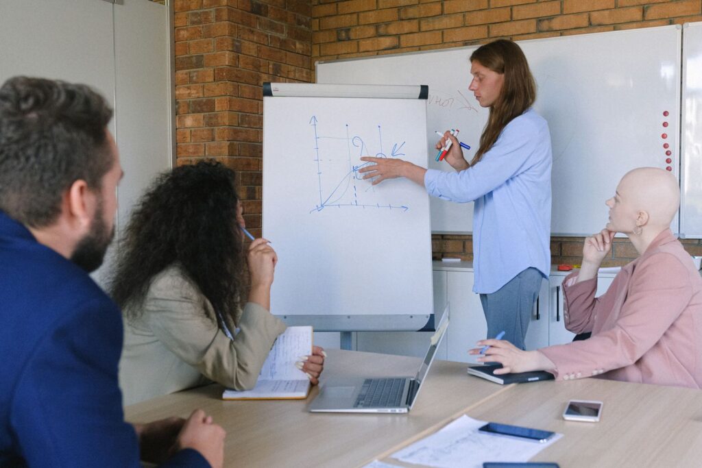 Εκπαιδεύτρια παρουσιάζει σε flipchart σε μικρή ομάδα